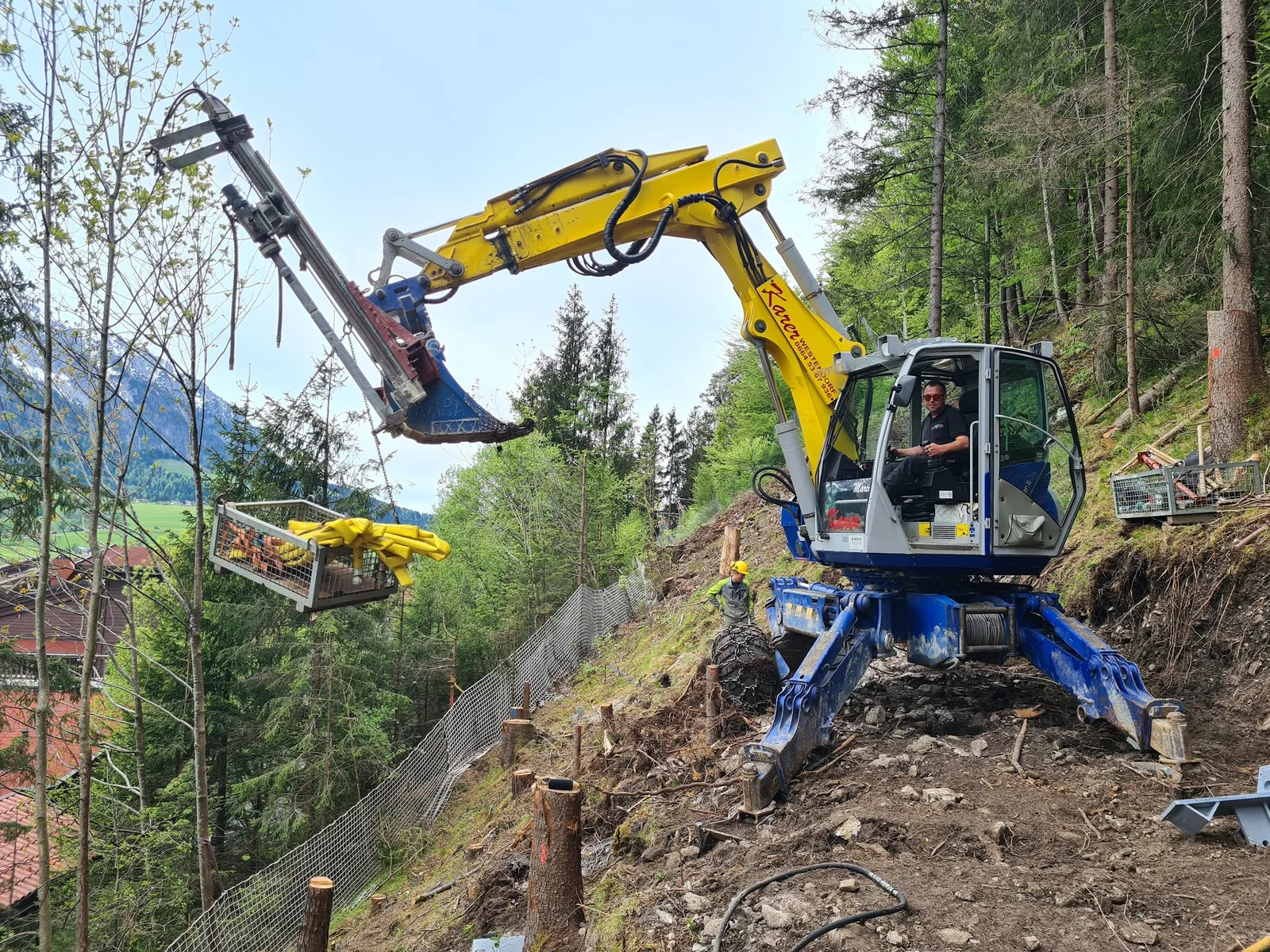 Schreitbagger und Mitarbeiter an einem Steilhang